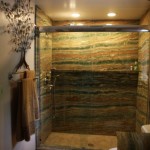 Esmerald Onyx Slab Shower with a Fossil Green Limestone one piece shower base. The bathroom floor is Gold Travertine cut to resemble wood planking